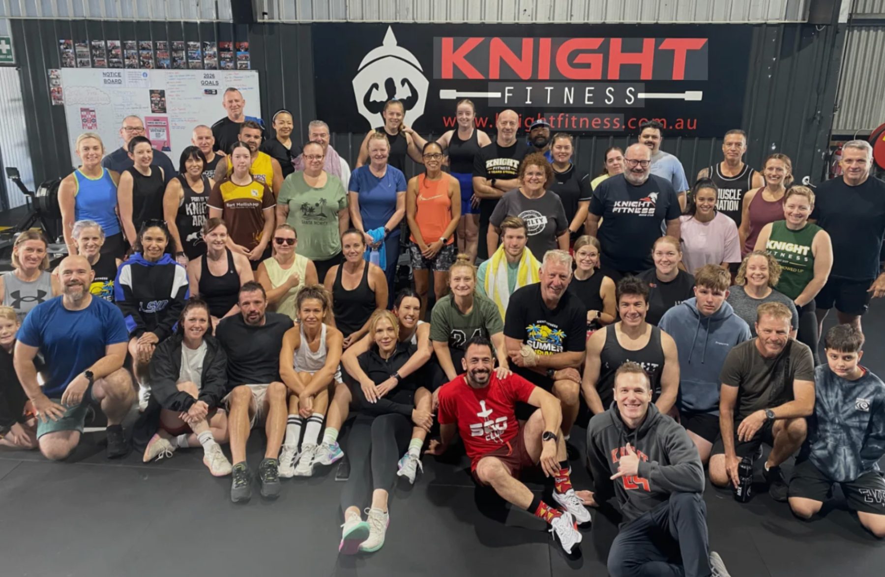 Around sixty Knight Fitness Morayfield members together in front of the studio sign