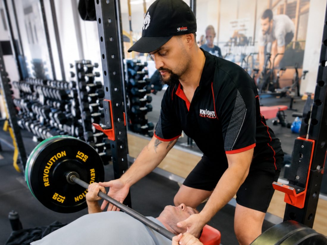 Coach Keri spotting a member on the bench press